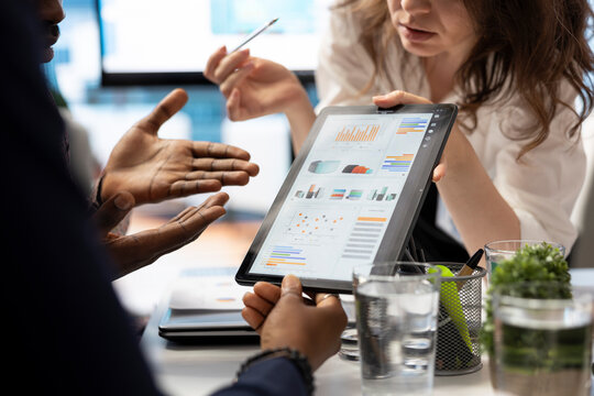 Project manager and staff engaging in a collaborative briefing meeting, using the interactive board and data visualization tools to present potential expansion solutions and tactics. Close up.