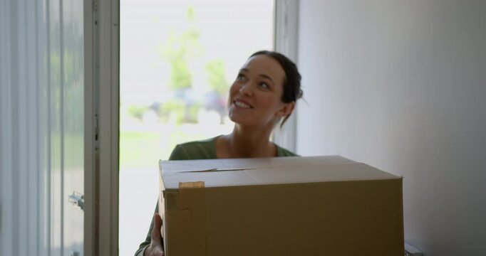 Single Adult Female Carrying Cardboard Boxes, Moving into new Home