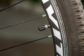 A valve with a cap on a bicycle wheel, close-up