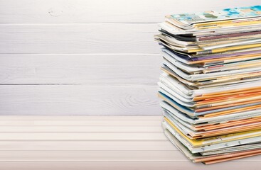 Pile of old retro paper magazines on background