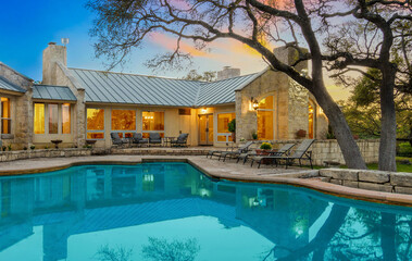 Beautiful stone house by the pool at sunset in a tranquil outdoor setting surrounded by trees