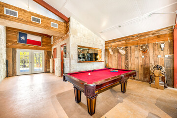 Cozy game room with a pool table and rustic decor in a Texas cabin during the day