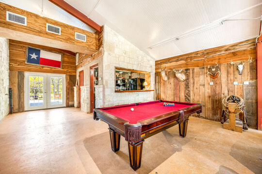 Cozy game room with a pool table and rustic decor in a Texas cabin during the day
