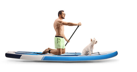 Full length profile shot of a man with a dog paddling a SUP board on knees