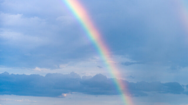 Blue summer sky with beautiful rainbow over the clouds