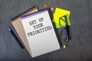 SET UP YOUR PRIORITIES text on a clipboard on wooden background.