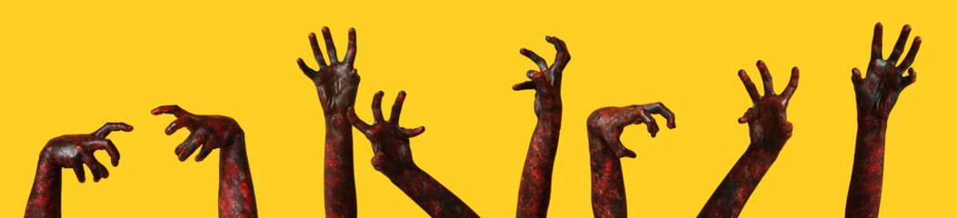 Many hands of zombies on yellow background. Halloween celebration
