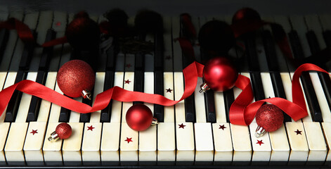 Piano keys with Christmas balls and red ribbon