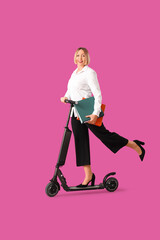 Beautiful mature businesswoman with kick scooter and folders on purple background