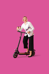 Beautiful mature businesswoman with kick scooter and cups of coffee on purple background