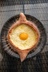 Adjarian khachapuri. Traditional Georgian dish made from a bun with cheese and egg. Selective focus.