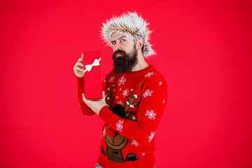 Xmas present and gift. Winter shopping sale. New Year and Christmas. Xmas holiday present. Man at New Year sale. Man hold holiday shopping gift from Santa in studio. Seasonal goodwill