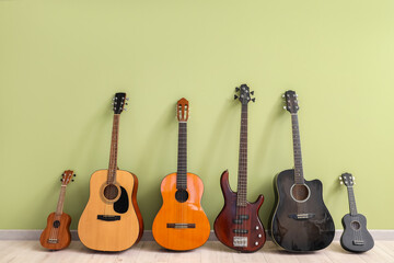 Naklejka premium Different guitars near green wall