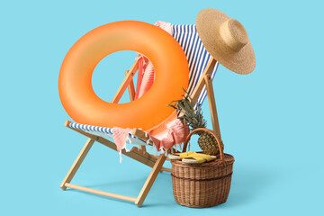 Inflatable ring, deck chair and basket with pineapple and flip-flops on blue background. Travel...