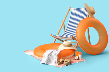 Inflatable ring, deck chair and beach accessories on blue background. Travel concept