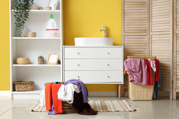 Stylish bathroom with sink, laundry baskets and folding screen