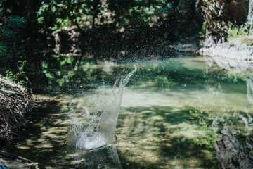 A dynamic splash captured in a serene forest creek, showcasing the beauty and tranquility of nature...
