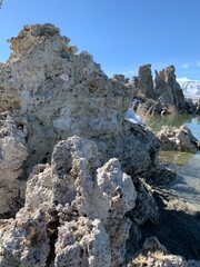 A breathtaking view of the unique salted rock formations that emerge from the surface of Mono Lake, set against a clear, deep blue sky.