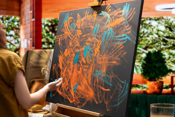 In a creative workshop, female artist mixes pigments with her fingers to achieve the perfect hue....