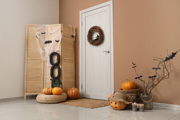 Interior of hallway decorated for Halloween with door, folding screen and pumpkins