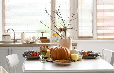 Autumn table setting with pumpkins in kitchen