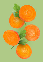 Round carrot slices and parsley in air on pale green background