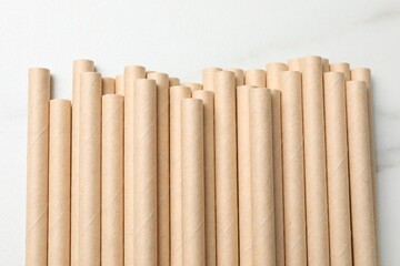 Many bamboo drinking straws on white table, top view