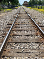 Fototapeta premium Close-Up Shot Of Railroad Tracks Leading To A Distant Station Building.