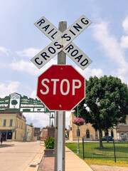 Stop Sign At Railroad Crossing With Buildings And Sky In The Background.