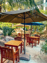 Outdoor Seating Area With Wooden Tables And Chairs Under Large Umbrellas at a resort hotel in Southern California