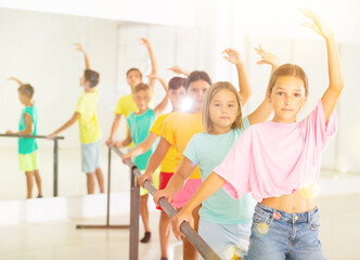 Fototapeta premium Youth girls and boys training ballet moves in studio.