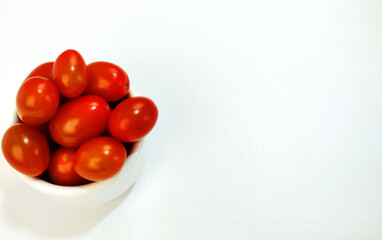 Isolated  bowl full of ripe cherry tomatoes with copy space.
