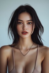 Naklejka premium A captivating portrait of a young woman showcasing natural beauty and elegance with soft lighting and a minimalist background.