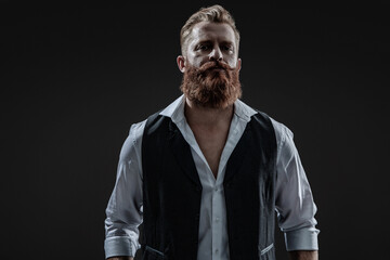 Brutal elegant bearded redhead man with red beard in formal menswear isolated on grey