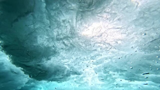 Ocean wave. Underwater view of clear ocean wave breaking over corral reef. spinning vortex, clouds. powerful nature, strong wave, danger of drowning. slow motion.