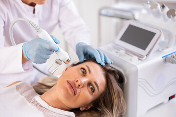 RF lifting and deep hydration for facial skin on young woman in cosmetology clinic