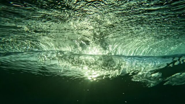 Ocean wave. Underwater view of clear ocean wave breaking over corral reef. spinning vortex, clouds. powerful nature, strong wave, danger of drowning. slow motion.