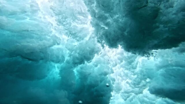 Ocean wave. Underwater view of clear ocean wave breaking over corral reef. spinning vortex, clouds. powerful nature, strong wave, danger of drowning. slow motion.