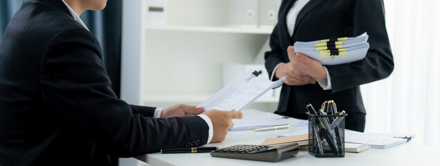 Corporate accountant team use calculator to calculate and maximize tax refunds and improve financial performance based on financial data report. Modern business accounting in panorama. Shrewd