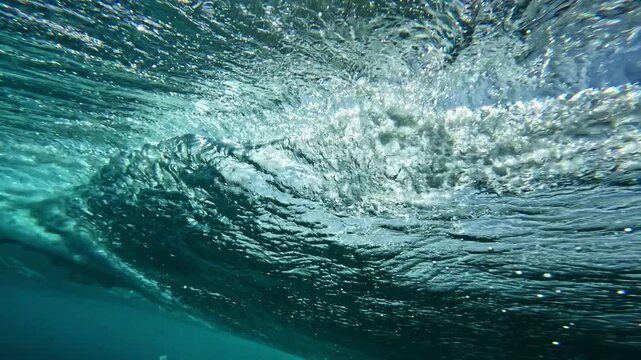 Ocean wave. Underwater view of clear ocean wave breaking over corral reef. spinning vortex, clouds. powerful nature, strong wave, danger of drowning. slow motion.
