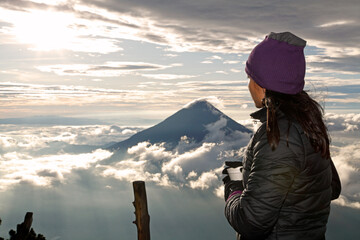 Backpacking woman contemplating the sunrise in the mountains
