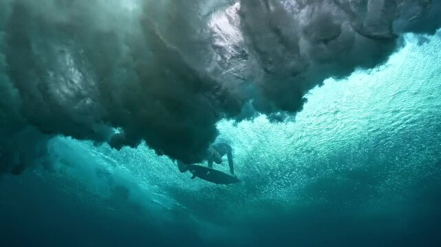 Underwater view of surfer dive under wave breaking over coral reef. Oahu north shore famous action sports destination. travel in Hawaii. slow motion 4k.