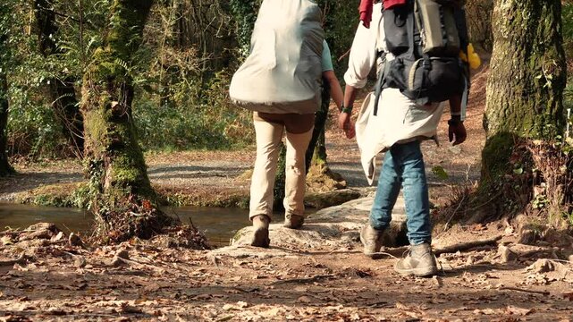 caminantes sin rostro haciendo el camino de santiago Compostela Espa&ntilde;a en un hermoso paisaje en el bosque en oto&ntilde;o caminando por el sendero entre los arboles