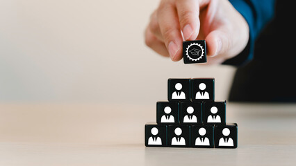 Naklejka premium Reskill concept to training employees, Digital and AI technologies transforming. New occupations emerge and workforce adaptation, Man holds black cube with ability skill icon on many staff icon symbol