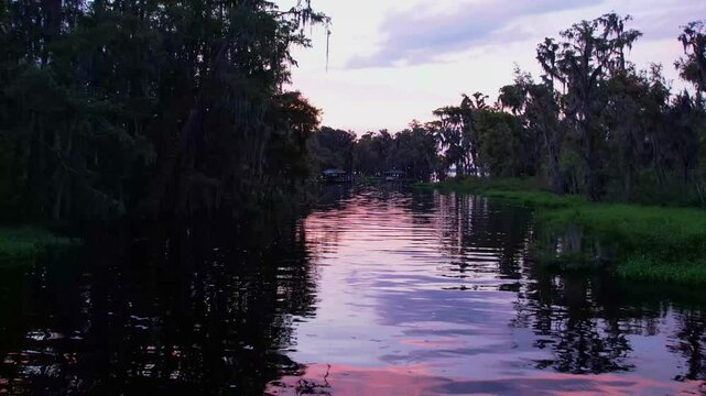 drone footage of an inlet stream leading to lake minnehaha in clermont florida at sunset
