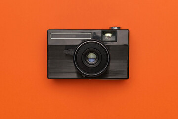 Fototapeta premium Vintage Black Camera on Vibrant Orange Background