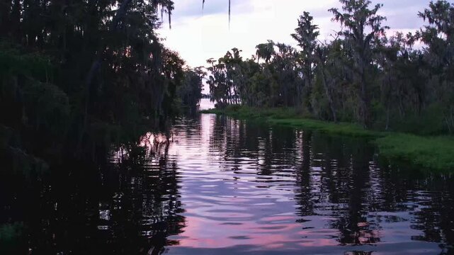 drone footage of an inlet stream leading to lake minnehaha in clermont florida at sunset
