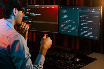 Working IT developer concentrating online software while drinking coffee on surrounded by coding...