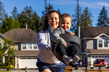 Obraz premium Mother and Child Enjoying Playtime on Swing Set in Mission, BC Neighborhood