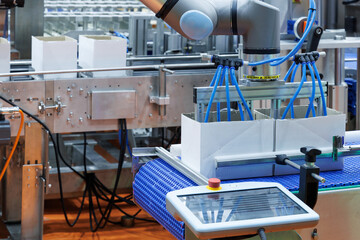 technology automated robotic arm handling product packaging to cardboard boxes on a conveyor belt in modern industrial production line in factory. innovation logistic and production line system
